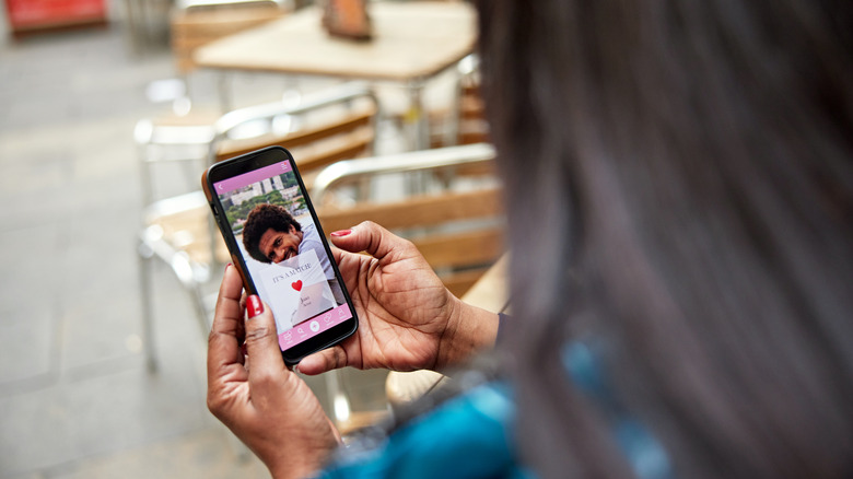 A woman checking out a man's profile on a dating app