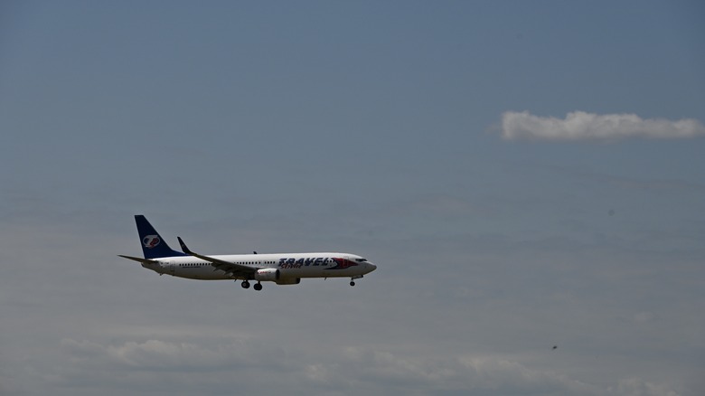 Boeing 737 at altitude in partly cloudy sky