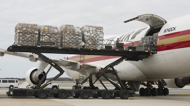 personnel load supplies aboard a CRAF plane