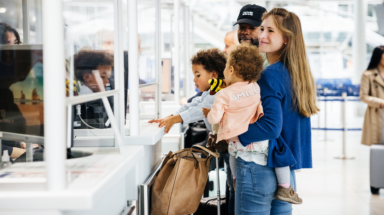 passengers talking to officer at a counter