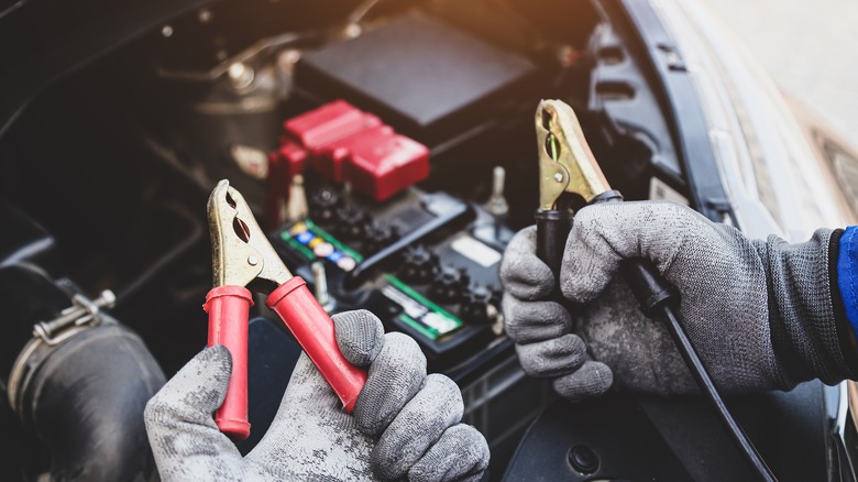 Man holding jumper cable leads