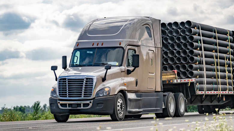 A semi truck carrying a load of pipes