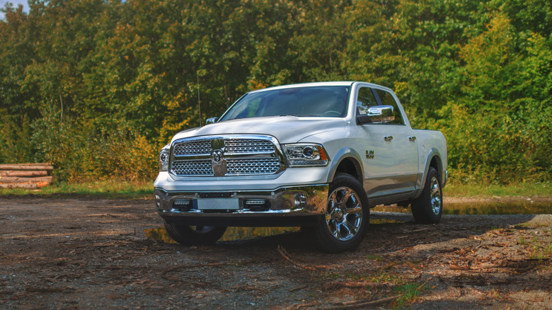 A front 3/4 shot of a white Ram 1500 EcoDiesel parked on a forrest trail.