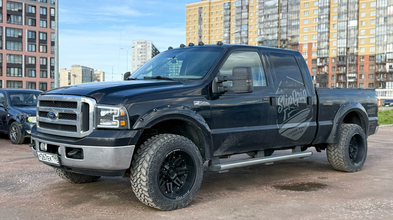 black Ford F-350 parked in dirt lot in city