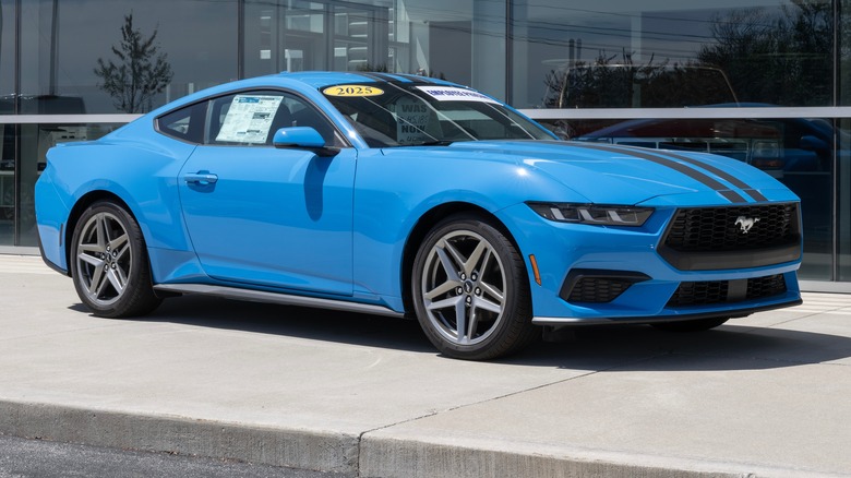 2025 Ford Mustang EcoBoost parked on a paved surface in front of a building