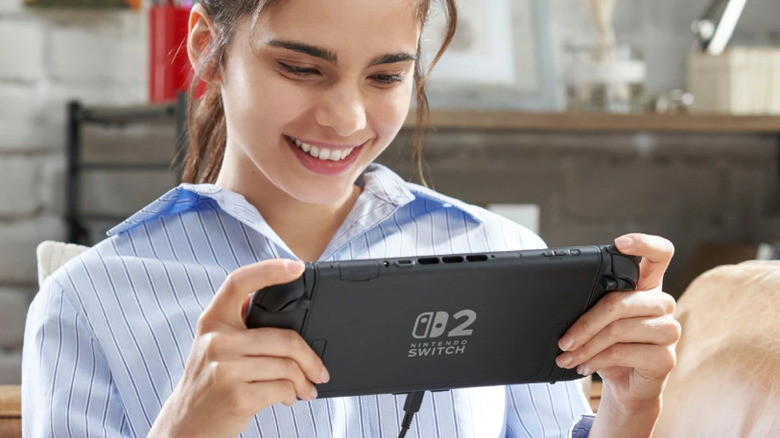 Someone playing the Nintendo Switch 2 in handheld mode, plugged into the USB-C charger.