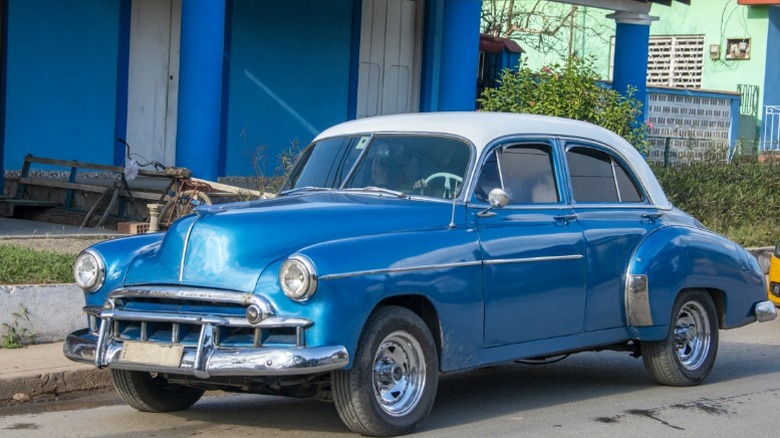 a blue vintage vehicle parked on a residential street