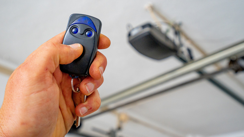 Hand pressing button to activate garage door opener