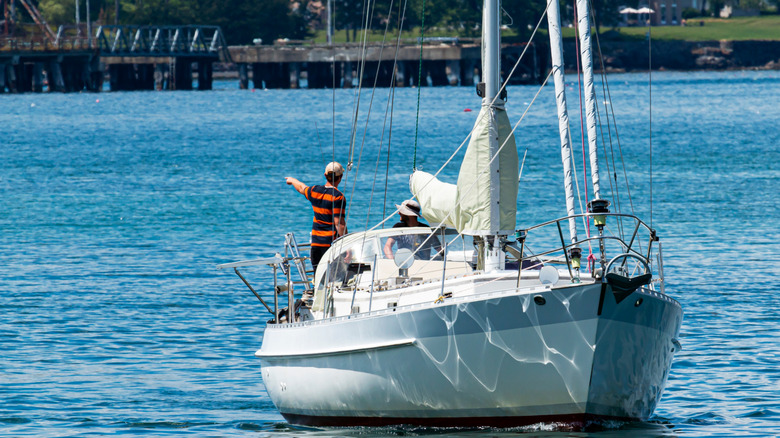 Sailboat in the east side waters of Bar Harbor using its motor engine to head out for the day.