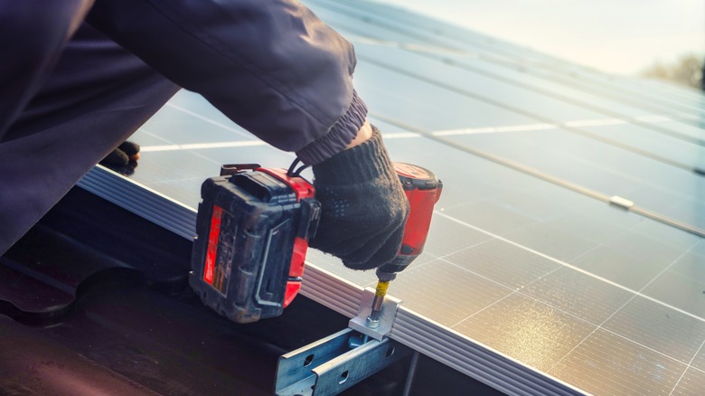 Worker installing roof solar panels