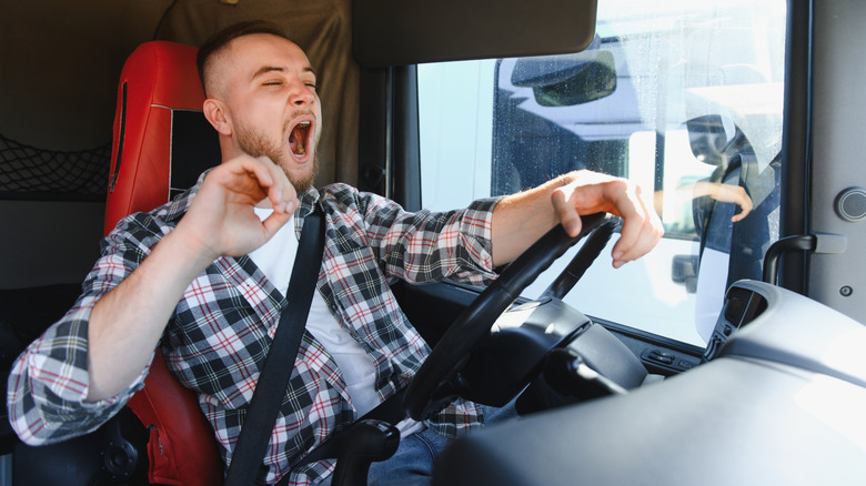 Truck driver yawning while behind the wheel