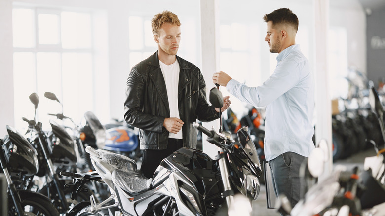 Two men in the middle of a motorcycle transaction