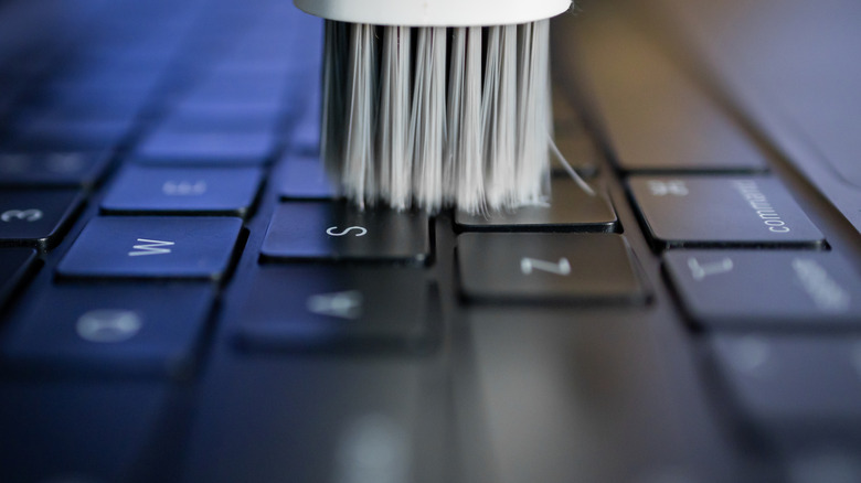 Soft-bristled brush going over laptop keyboard