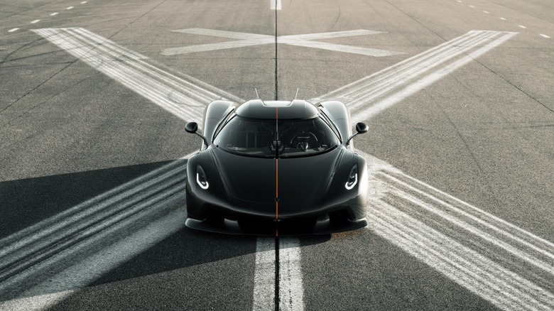 Front view of the Koenigsegg Jesko Absolut on a runway, black with orange stripe