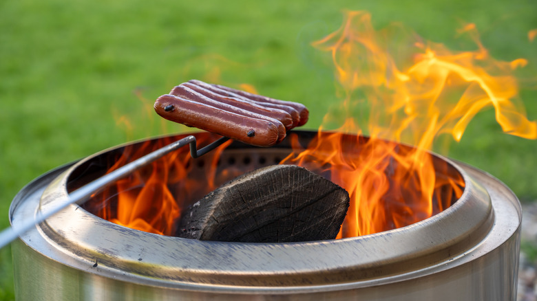 Cooking hot dogs over a smokeless fire pit