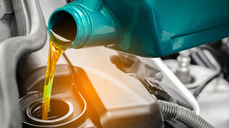 Pouring motor oil into car engine