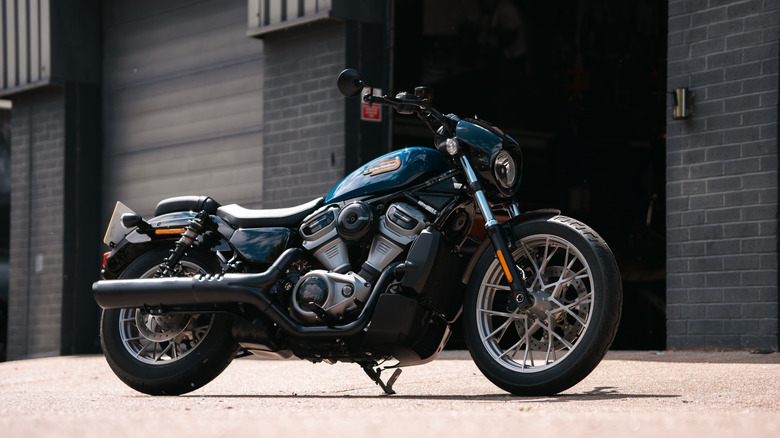 Blue Harley-Davidson Nightster in front of a black brick garage.