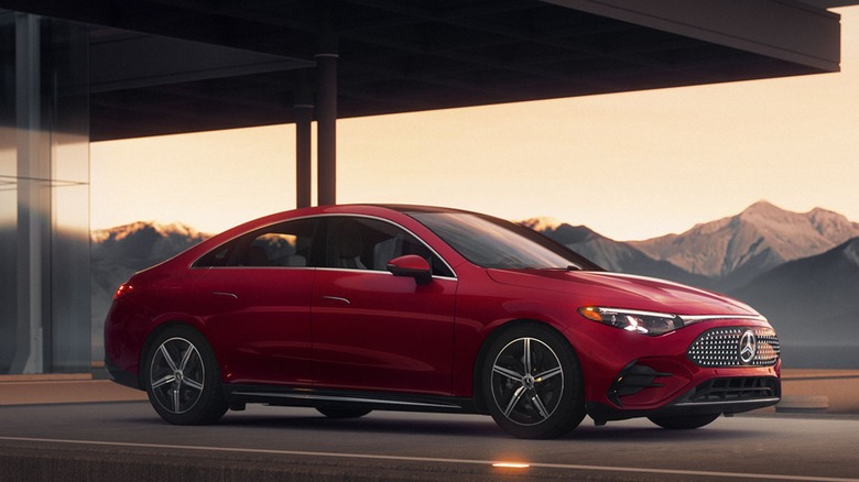 A red Mercedes Benz CLA parked by a generic glass building