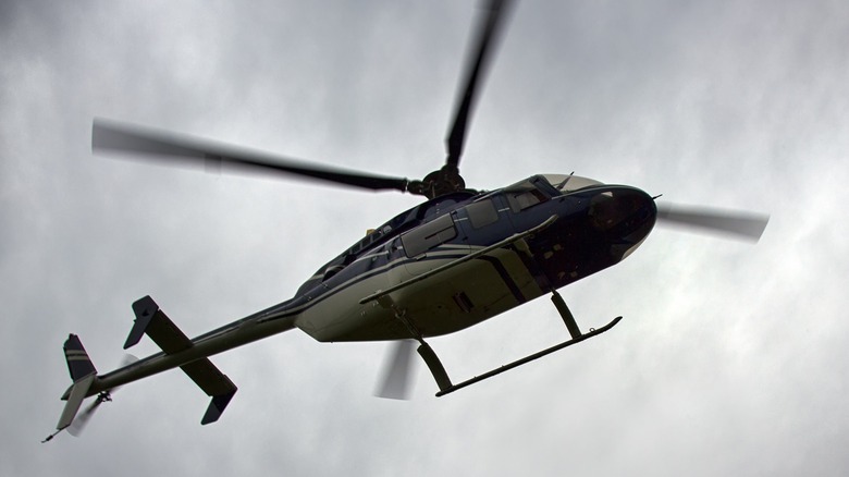 Civilian helicopter flying in a cloudy sky