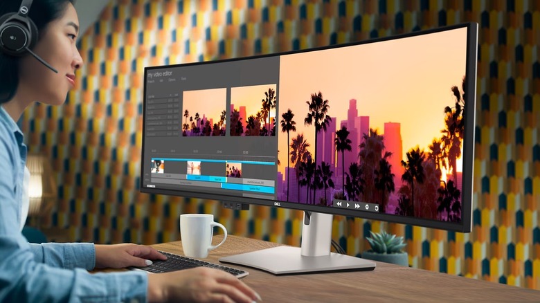 Woman using Dell 32:9 super-widescreen monitor to edit media