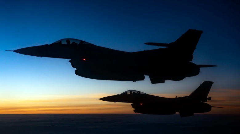 The silhouette of two F-16s flying side-by-side