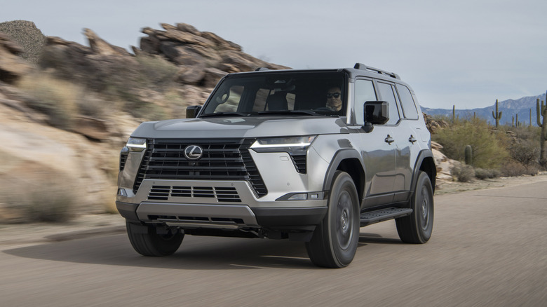 A gray Lexus GX driven on paved desert roads.