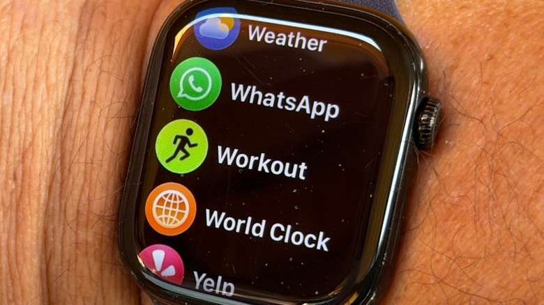 Apple Watch on Adam's wrist with WhatsApp on app screen list
