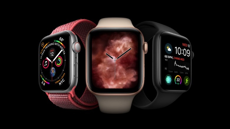 Three Series 4 Apple Watches on black background