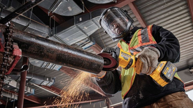 A worker using the DeWalt 60V Max Grinder