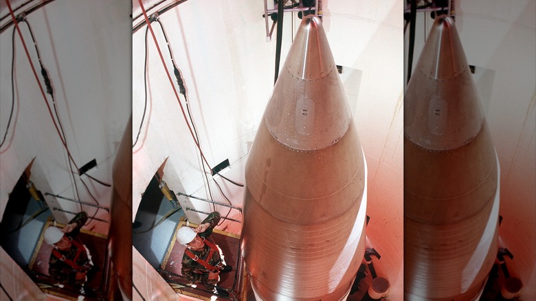A worker looks upon a Minuteman III missile in its silo