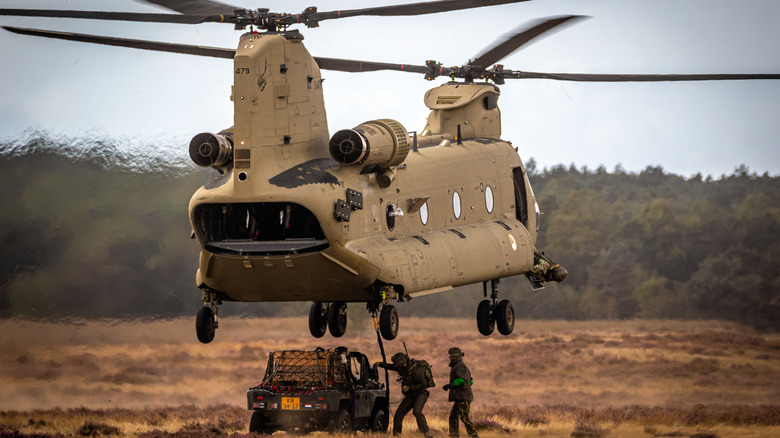 Dutch soldiers attatching a military all-terrain vehicle as a sling load to a Boeing CH-47F