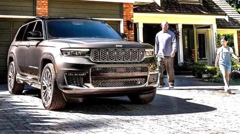 Father and daughter walking toward a Jeep parked in a driveway.