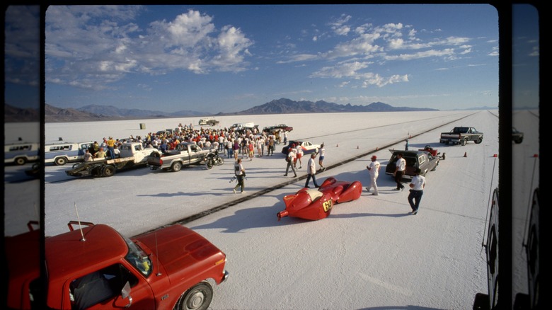 A crowd of spectators and drivers gathers at the Bonneville Flats starting line