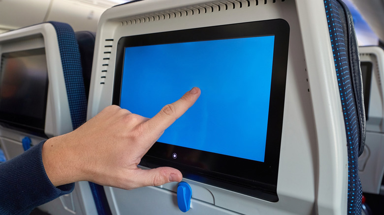 Using a blank seatback touchscreen during a flight.