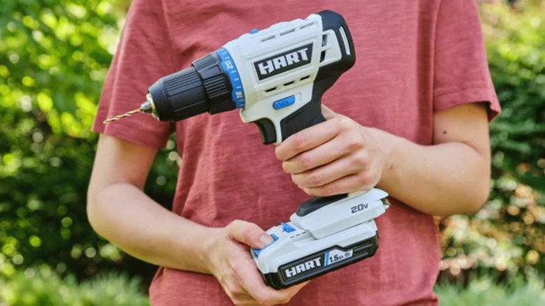 A person putting a battery in a Hart drill