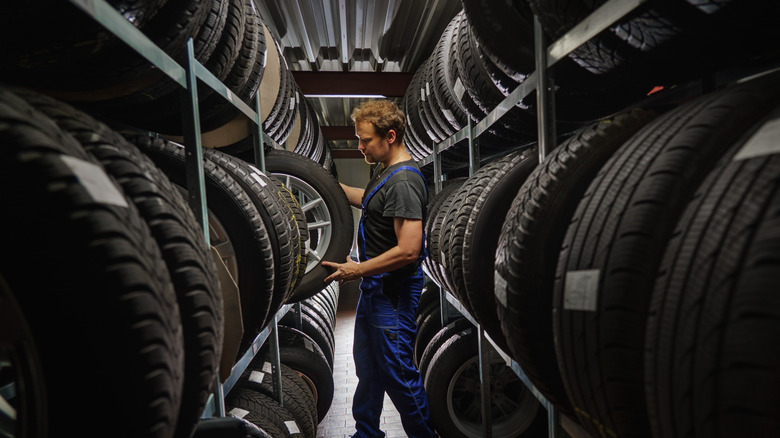 Hardworking experienced worker holding tire