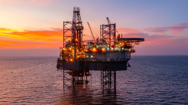 Aerial view of silhouette offshore jack up drilling rig during sunset