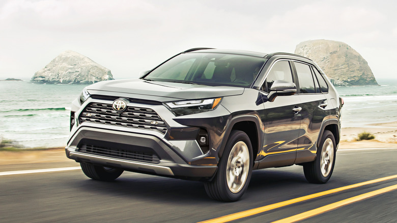 A black 2025 Toyota RAV4 on a highway