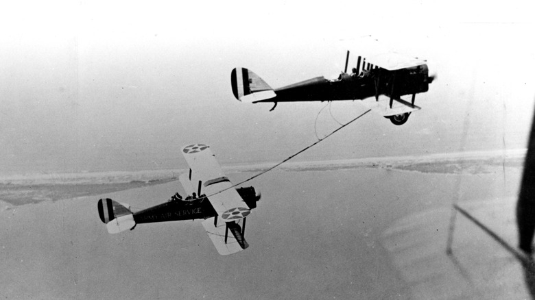 First air to air refueling between two DH-4B airplanes. Seifert and Hine (top) transfer fuel to Richter and Smith on June 27, 1923.