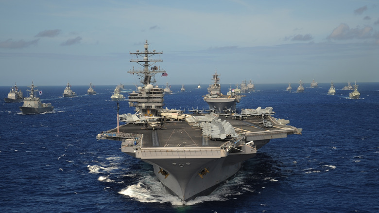 The Nimitz-class aircraft carrier USS Ronald Reagan leads a mass formation of ships