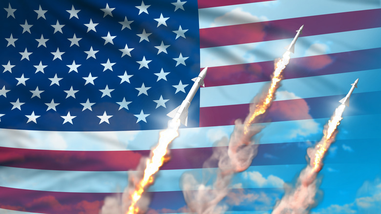 Three nuclear missiles launched over a backdrop of the American Flag.