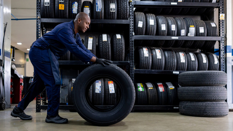 Tire technician rolling a tire in tire store