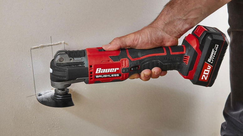 Bauer multitool cutting a square piece out of drywall