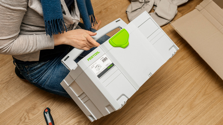 A person sitting on floor with new Festool boxed tool