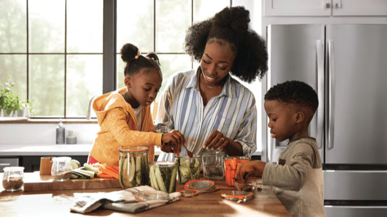 Woman with kids in kitchen with Frigidaire refrigerator in background