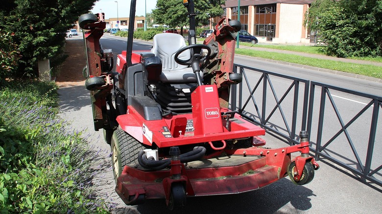 Toto riding lawn mower parked on sidewalk