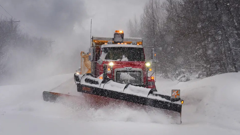 Western Star snowplow truck at work on wooded road, front-view