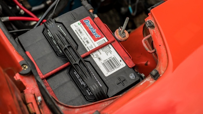A flooded lead acid Duralast battery installed in a well-used automobile.