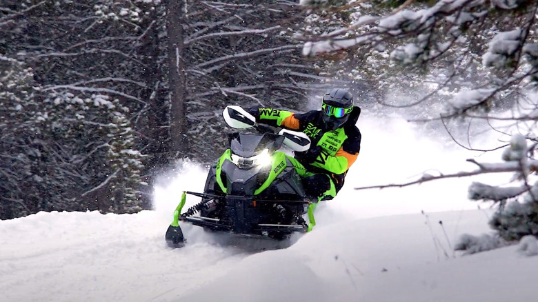 Person riding Arctic Cat snowmobile