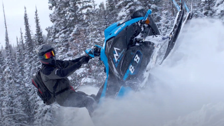 Person riding Arctic Cat snowmobile